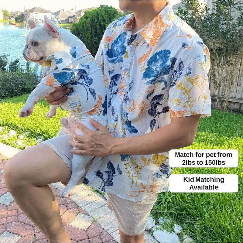 Matching watercolor floral print shirt set for male owner and French Bulldog, with text indicating the set fits pets from 2lbs to 150lbs and includes kid sizes, shown outdoors by a lake.