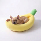 French Bulldog sound asleep on soft plush banana pet bed, warm enclosed nest bed reduces puppy anxiety