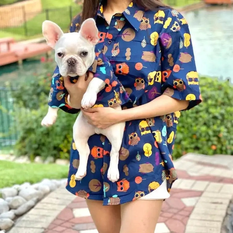 Matching owl print shirt set for owner and French Bulldog, featuring a women’s button-up and a dog shirt, worn outdoors by a lake.