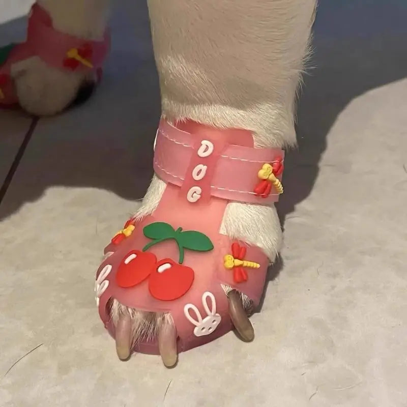 Close-up of pink pet sandals with cherry, rabbit, and dragonfly decorations for French Bulldogs, highlighting breathable design.