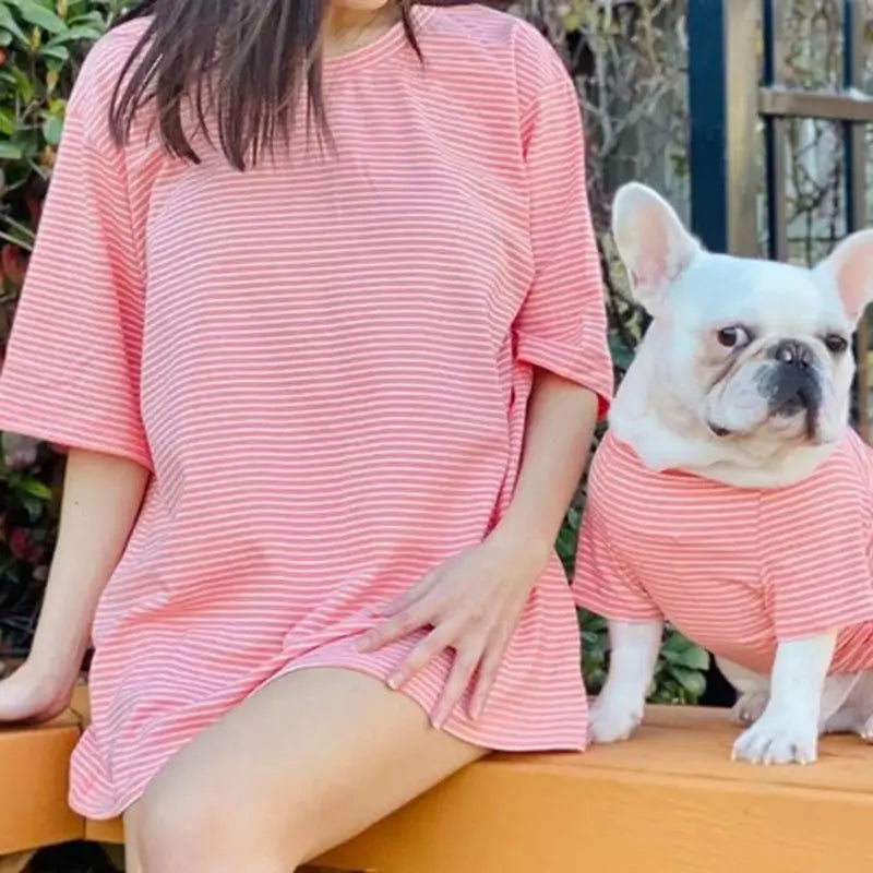 Matching pink and white striped outfit for owner and French Bulldog, featuring an oversized women's dress and a dog shirt.