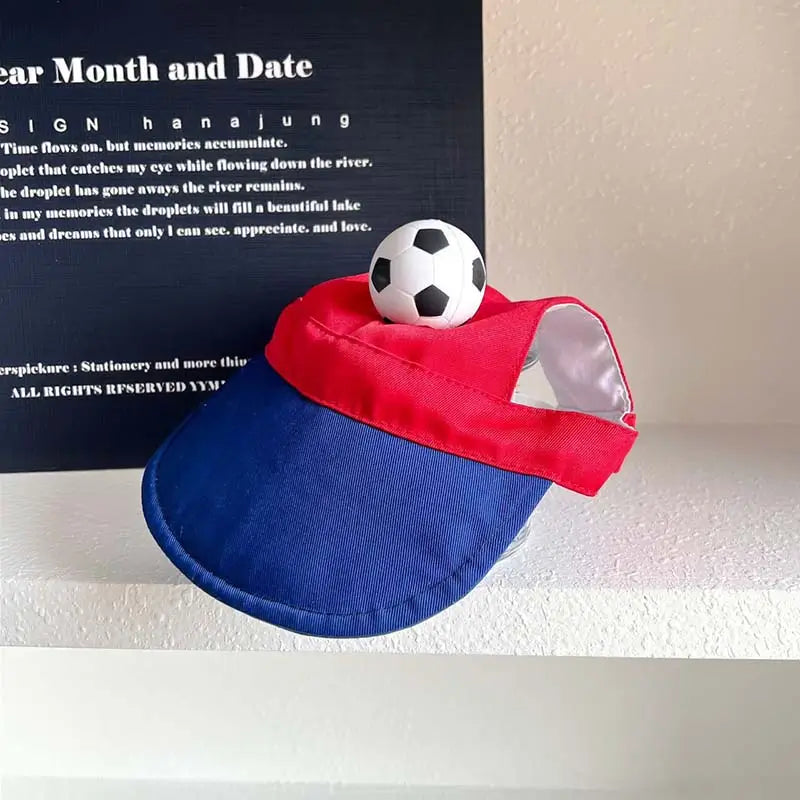 Red and blue dog sun visor with a 3D soccer ball decoration, adjustable strap, designed for French Bulldogs and small dogs.
