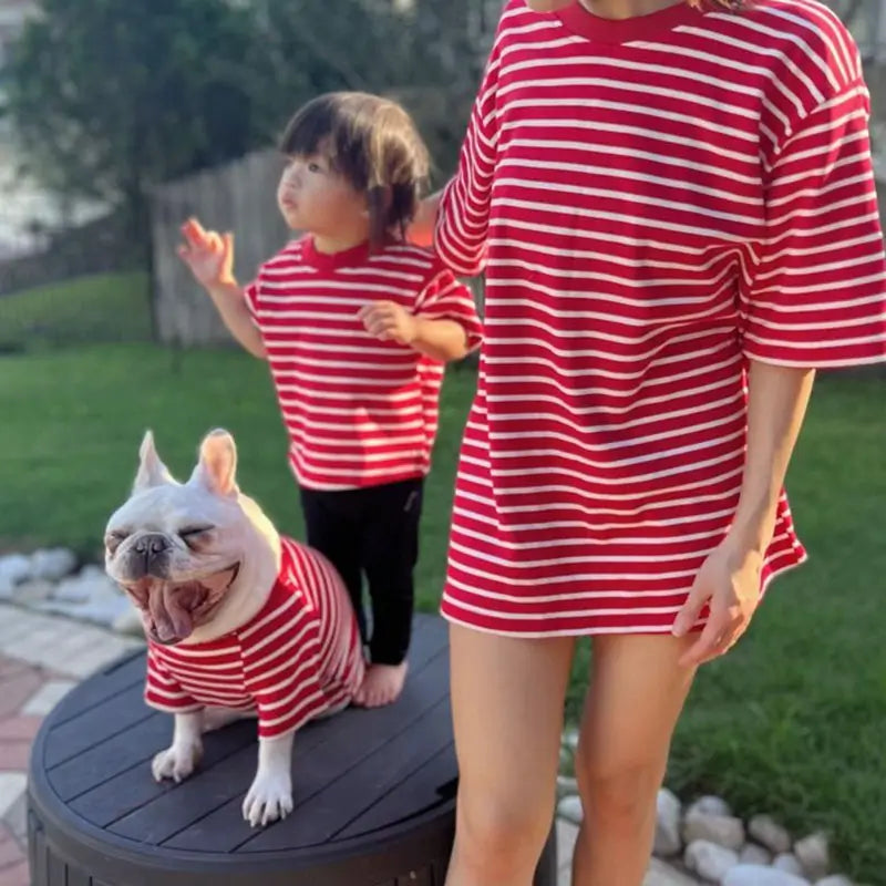 Family matching red and white striped clothing set for mom, kid, and French Bulldog, showing coordinated styles for all family members.