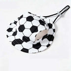 Black and white soccer ball patterned bucket hat for dogs, designed with ear holes and an adjustable chin strap, shown on a white background.