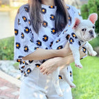 Owner and French Bulldog wearing matching white daisy print shirts, twinning dog and human outfits by Frenchie Nest