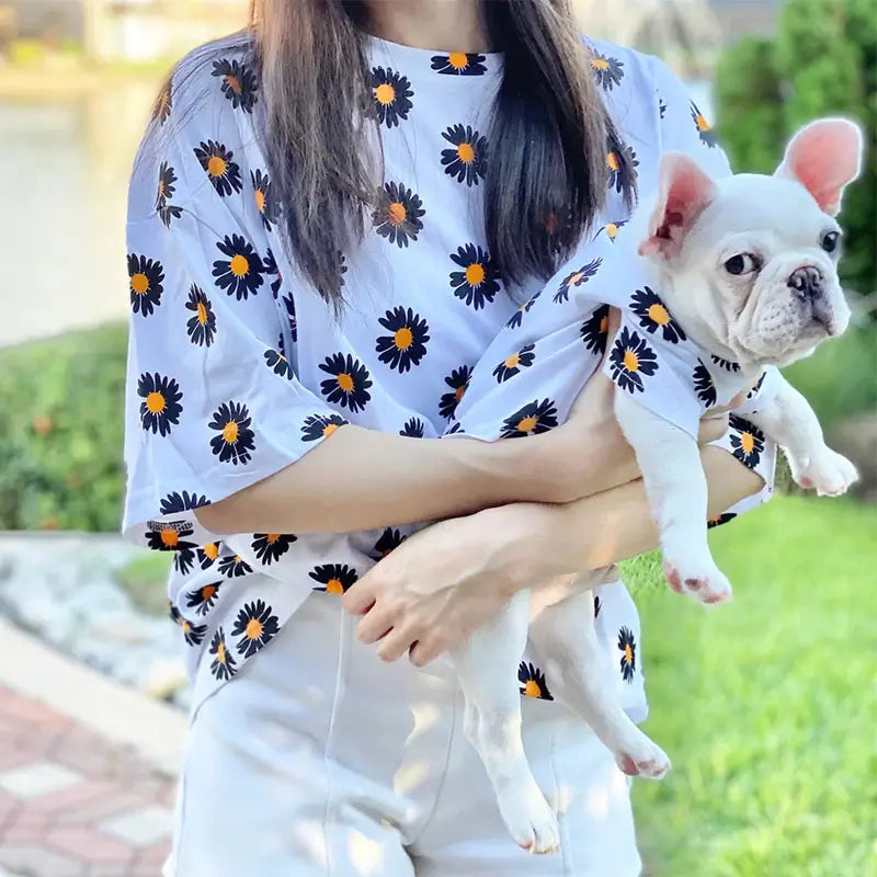 Owner and French Bulldog wearing matching white daisy print shirts, twinning dog and human outfits by Frenchie Nest